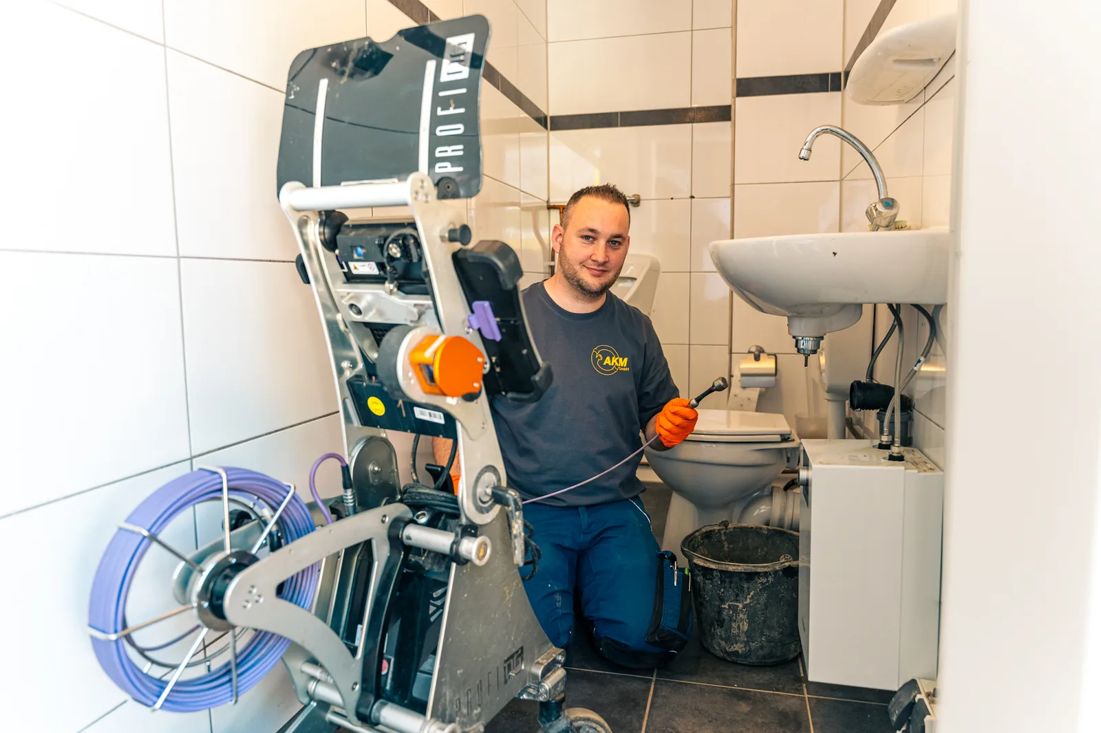 Techniker reinigt einen verstopften Küchenabfluss beim Kunden